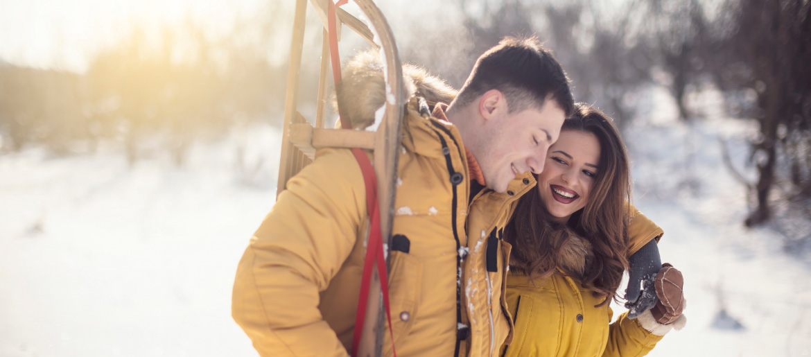 junges Pärchen im Winter mit Schlitten